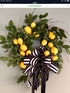 a wreath with oranges and green leaves hanging on the wall