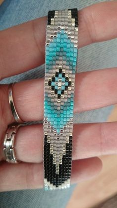 a woman's hand holding a beaded bracelet