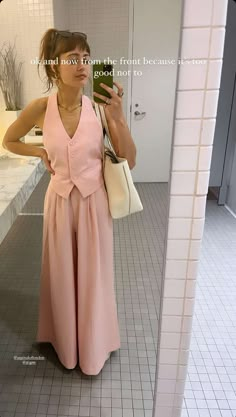 a woman taking a selfie in a bathroom mirror with her cell phone up to her ear