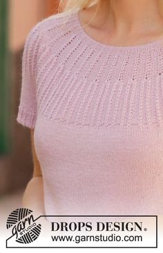 a woman with blonde hair wearing a pink sweater