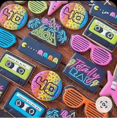 decorated cookies are laid out on a table with sunglasses, tape recorders and other items