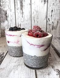 two dessert cups with berries and chia seeds on top