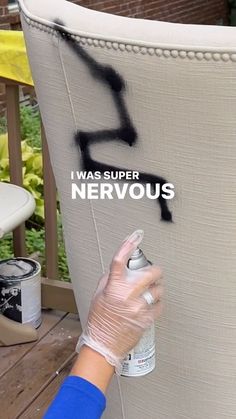 a person spray painting the side of a large white chair with black paint on it that says, i was super nervous