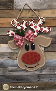 a reindeer door hanger with red and white polka dots on it's nose