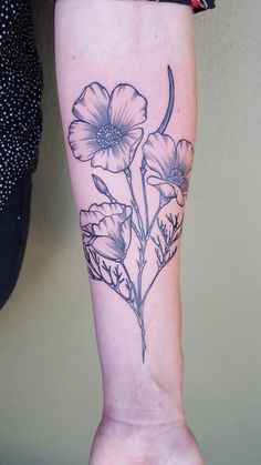 a woman's leg with flowers on it and the bottom part of her arm