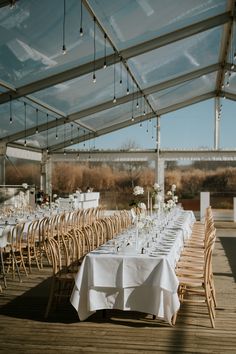 tables and chairs are set up for an outdoor wedding reception under a tented area