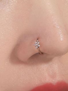 a close up view of a nose with a diamond ring on it