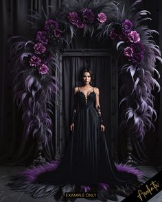 a woman standing in front of a black backdrop with purple flowers and feathers on it