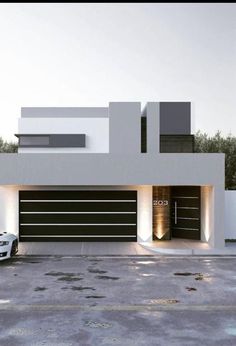 a car is parked in front of a modern house with lights on the garage door