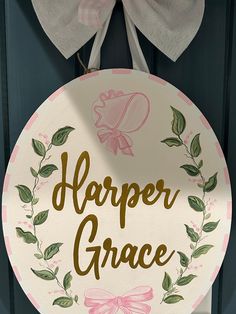 a sign that says harper grace hanging on a door with a bow around it's neck