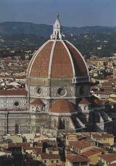 an aerial view of the dome of a building with many rooftops and buildings around it