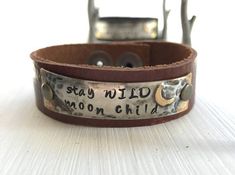 *This listing is for one hand made leather cuff measuring 3/4" wide with a metal piece which is soldered and then hand stamped with   stay WILD moon child    with a moon off to the side.*Sizing options:  The Regular size option is a cuff that will fit a wrist which is 6 1/2" up to 7".   The Large size option is a cuff that will fit a wrist which is 7 1/4" up to 8".  The XLarge size option is a cuff that will fit a wrist 8 1/4" up to 9".  If you are unsure of which size is right for you, please c Child Hand, Stamped Leather, Stay Wild Moon Child, Wild Moon, Leather Cuff Bracelet, Stay Wild, Leather Cuffs Bracelet, Kids Hands, Paper Tape