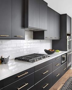 a kitchen with black cabinets and white counter tops