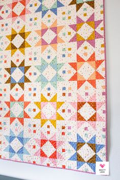 a colorful quilt hanging on the wall