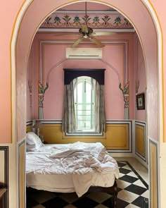 a bedroom with pink walls and black and white checkered floor