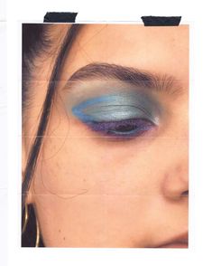 a woman's eye with blue and silver makeup on her eyeshadow is shown