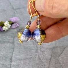 ✦Add a touch of elegance to your jewelry collection with these stunning Purple and Gold Murano Glass Bead Earrings. These unique earrings make the perfect gift for mom or a special someone in your life.  ✦The handcrafted brilliant Italian Murano glass Venetian beads round beads have beautiful colorful hues of dark purple with gold and silver interior foil to create a stunning look. The beads measure 12mm and are accented with purple Swarovski 4mm bicone crystals.  ✦Earring length is approximately 1.5 inches.  ✦The high quality, 14k gold filled leverback ear wires ensure a secure fit. Also available with simple 14k gold filled French hook ear wires. Please select ear wire style at check out. ✦Want to upgrade your earrings with solid 14k gold ear wires? Click here to purchase the upgrade: ht Elegant Hypoallergenic Round Bead Earrings, Elegant Czech Glass Jewelry With Matching Earrings, Adjustable Lever Back Jewelry Gift, Adjustable Lever Back Jewelry As A Gift, Handmade Elegant Jewelry With Czech Glass, Elegant Handmade Jewelry With Czech Glass, Elegant Handmade Czech Glass Jewelry, Elegant Purple Earrings As A Gift For Her, Elegant Purple Earrings For Her