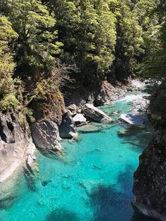 the water is crystal blue and clear in this river that runs between two rocky cliffs