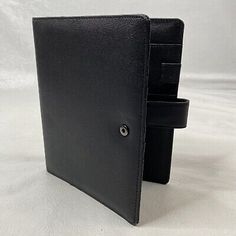 a black leather folder with two compartments on the front and one in the back,