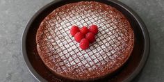 a chocolate cake with raspberries in the shape of a heart