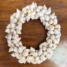 a wreath made out of sea shells on a wooden table