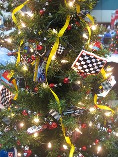 a decorated christmas tree with yellow ribbon and checkerboard ornaments on it's branches