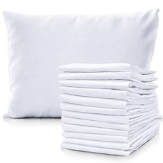 a stack of white pillows next to a pile of folded sheets on a white background