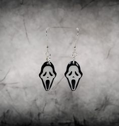 Introducing our GhostFace earrings, meticulously crafted by artist Jake Ashley in the U.S.A. Made with sterling silver hardware for quality and durability, these earrings capture the iconic horror character's essence with elegance. Perfect for horror fans and Scream enthusiasts alike, these statement pieces are sure to turn heads wherever you go. Dimensions: "Dangle" 1"x0.60" (GhostFace) Total Length 2" "Studs" 0.55"x0.33" Spooky Silver Pierced Earrings, Halloween Themed Silver Earrings, Silver Themed Earrings For Halloween, Themed Silver Earrings For Halloween, Spooky Silver Earrings For Gift, Halloween Themed Pierced Jewelry, Halloween Sterling Silver Dangle Earrings, Pierced Themed Jewelry For Halloween, Ghostface Earrings