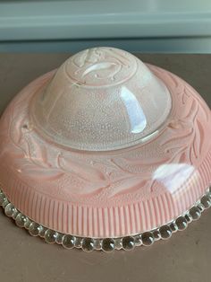 a pink glass dish sitting on top of a counter