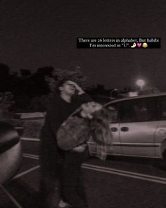 two people standing in front of a car at night with the caption there are 20 letters in alphabet