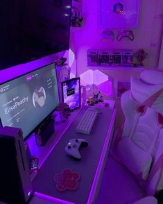 a computer desk with a keyboard, mouse and monitor in front of a purple light