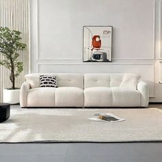 a living room with white couches and rugs on the floor in front of a window