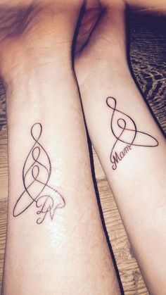 two people with matching tattoos on their arms, one is holding the other's hand