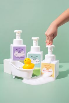 a soap dispenser with two bottles and a rubber duck