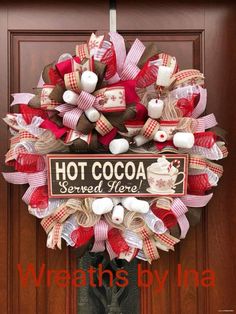 a red, white and brown wreath with hot cocoa sign on the front door that says hot cocoa served here