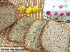 four slices of bread sitting on top of a bamboo mat next to a container with flowers