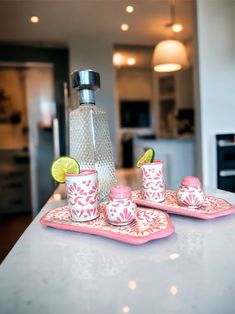 a kitchen counter with cups and saucers on it, lime wedges in the middle