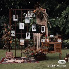 an outdoor area with pictures and flowers on the wall next to a wooden table in front of a tree