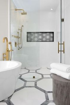 a bathroom with white walls and flooring has an oval bathtub in the center