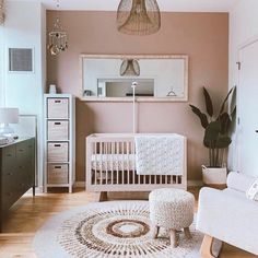 a baby's room with a white crib, chair and rug on the floor