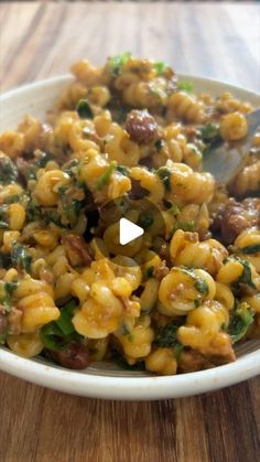 a white bowl filled with macaroni and cheese on top of a wooden table