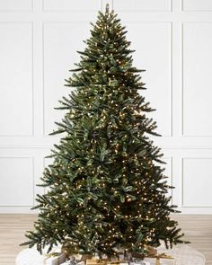 a small christmas tree sitting on top of a wooden floor next to a white wall