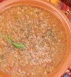 a brown bowl filled with soup on top of a colorful table cloth