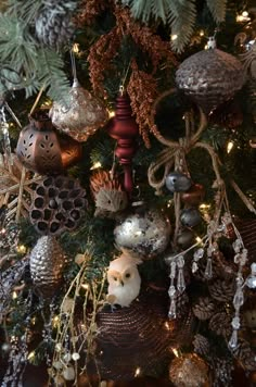 a christmas tree with ornaments hanging from it's branches and pine cones on top