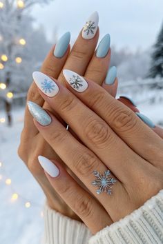 Celebrate the chill of winter with stunning nail art featuring icy blue and snowflake designs. This unique manicure combines matte and glitter finishes, capturing the essence of frost and snow. Perfect for the holiday season, these nails add sparkle and charm to your winter style.   #WinterNails #NailArt #FrostyNails #WinterNailIdeas #ChicManicure #NailDesigns #HolidayNails #Snowflakes #NailInspo January Nails Blue And White, Snowy Winter Nails, Snowflake Blue Nails, Blue Snowflake Nail Design, Snow Nails Winter White, Light Blue Nails With Snowflakes, Icy Winter Nails, Winter Nails Light Blue, Blue Snow Nails