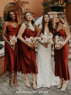 bridesmaids in red dresses laughing and posing for the camera with their bouquets