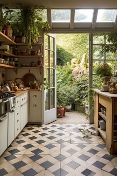 a kitchen filled with lots of potted plants next to an open door that leads into a garden