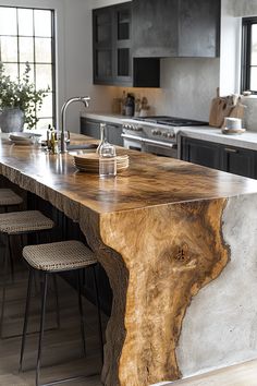 a large wooden table sitting in the middle of a kitchen next to two bar stools