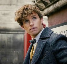 a man with curly hair wearing a suit and tie