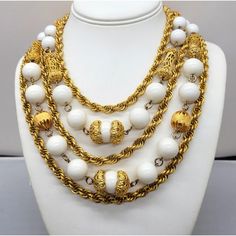 This is part of Chairish’s Costume Jewelry assortment.  1980s 5-strand goldtone 3 twisted chains with chains in between of round white resin beads and oblong filigree beads necklace with hook clasp. Marked "LES BERNARD INC." Measures: 7 1/2 inches long by 7 1/2 inches wide. Center measures: 2 inches long. Interior circumference is about 16 1/2 inches. Condition: Very good except that there is some goldtone loss around the clasp area from rubbing and a small spot of loss to the back of the clasp. White Beaded Necklaces With Round Beads And Chain, White Multi-strand Beaded Chain Necklace, Elegant White Rope Chain Necklace, Vintage Double Strand White Jewelry, Vintage White Double Strand Jewelry, Vintage White Beaded Chain Necklace, Vintage White Necklace With Beaded Chain, Vintage White Pearl Chain Jewelry, White Multi-strand Costume Jewelry Necklace